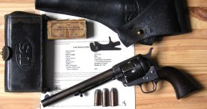 Antique pistol with Army holster and shell pouch on a table atop a letter of authentication from Colt.